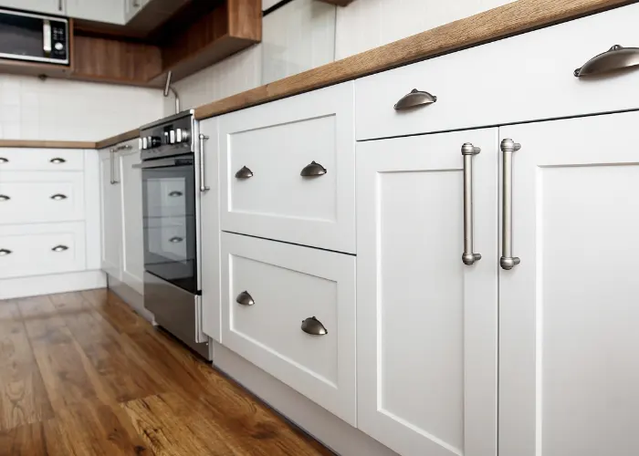 New white kitchen cabinets with brushed nickel handles and butcher block countertops