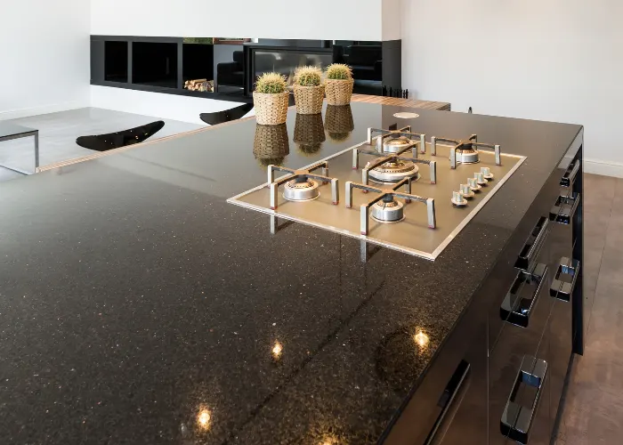 High-end modern kitchen with an island with a large dark brown granite countertop